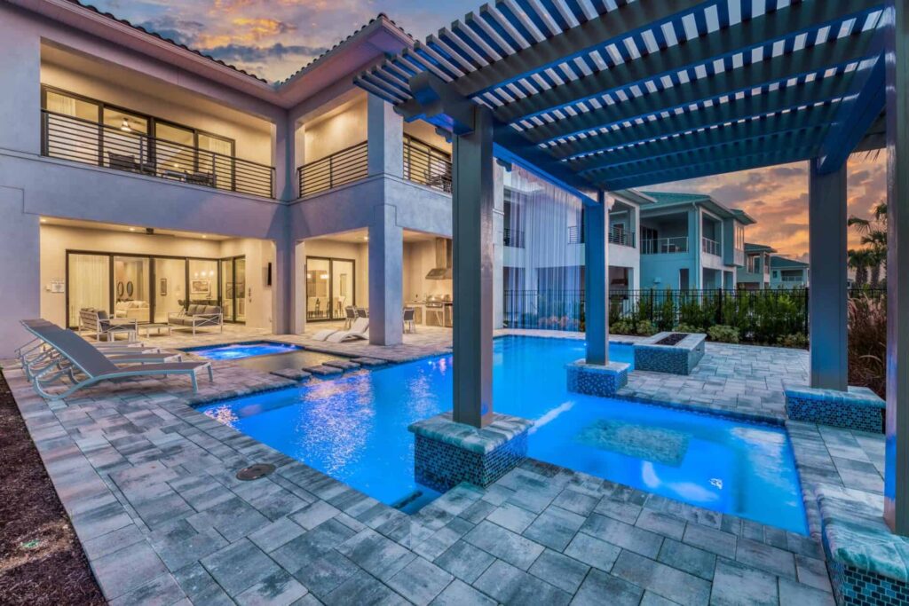 Private pool with waterfall trellis at luxury resort home at twilight