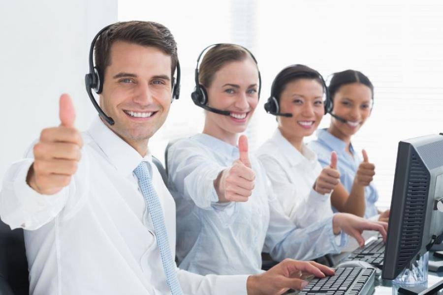 Smiling call center operators giving thumbs up gestures