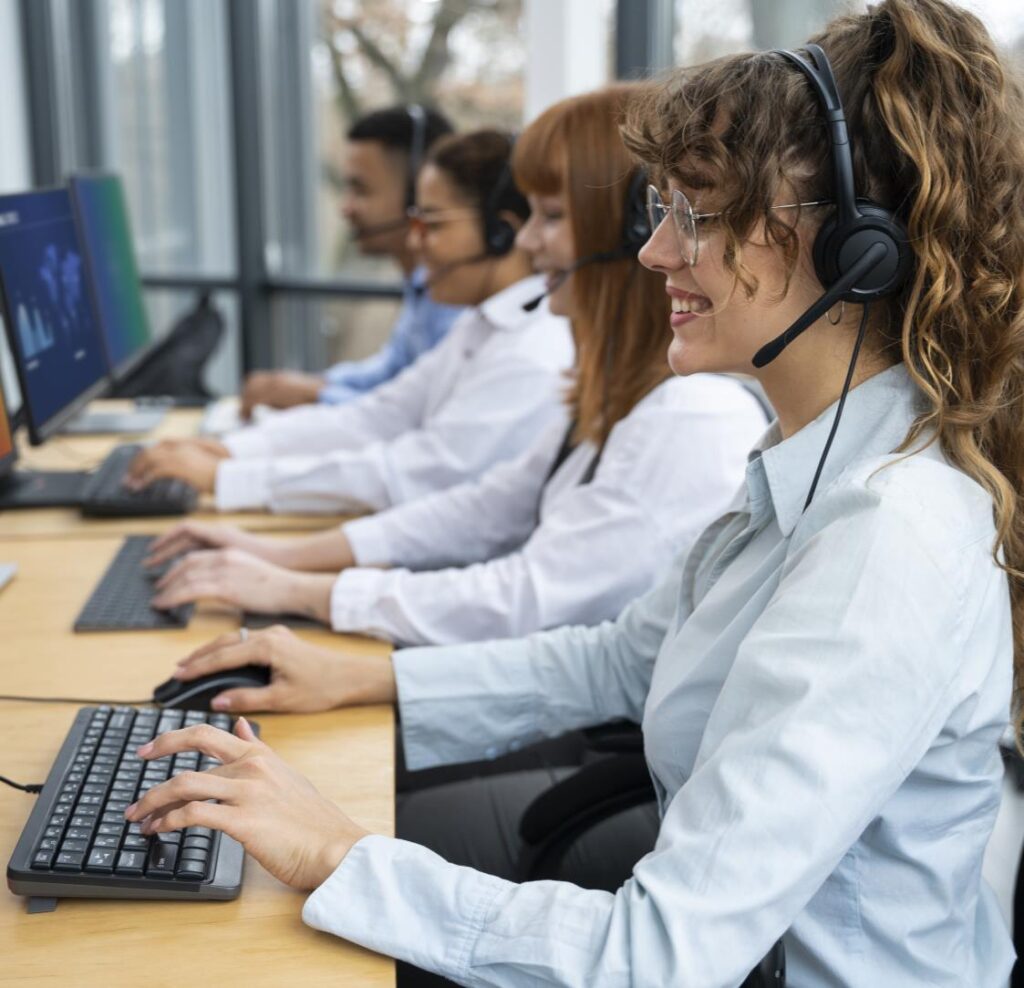 Row of smiling call center representatives helping customers on the phone