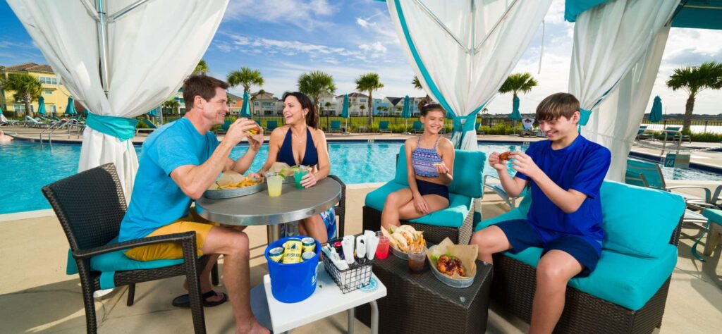 Family of four eating together under a private poolside cabana