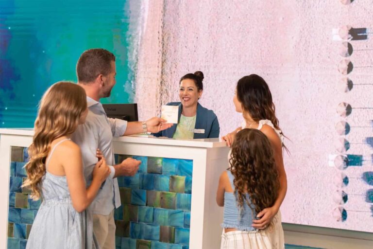Happy family checking in at the concierge desk of Margaritaville Resort Orlando.