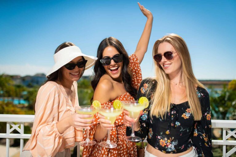 Marketing Agency lifestyle photo: Three woman holding margaritas on a balcony at Margaritaville Resort Orlando