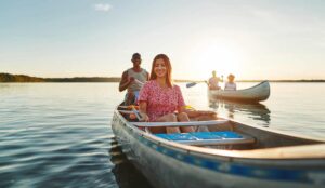 Two friends canoeing on a lake in the late afternoon