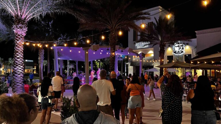 Crowd enjoying a nighttime concert at the Promenade at Sunset Walk