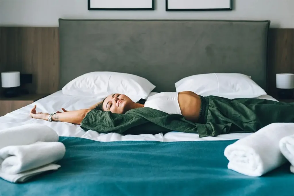 Woman lying stretched out on a bed in the morning (Olga Rolenko/Getty Images)